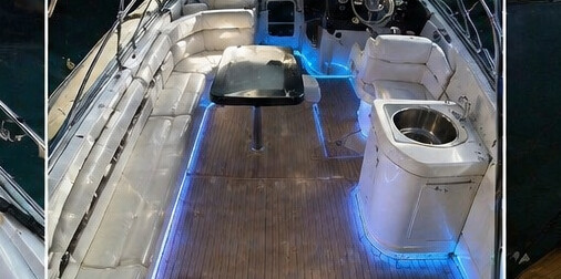 Teak deck on board Katia with blue LED ambient lighting and white leather seating